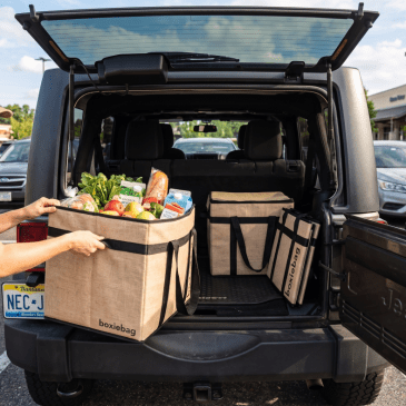 A woman loading boxiebags inside the back of her jeep made with AI.